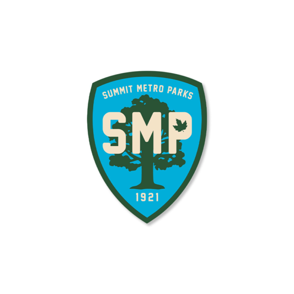 A blue shield with a dark gray border and tree in the background. Across the front of the tree in bold letters is SMP.