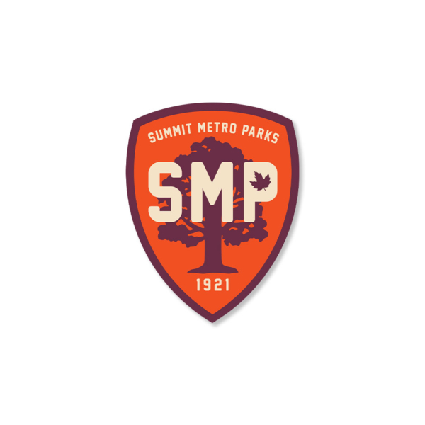 An orange shield with a dark gray border and tree in the background. Across the front of the tree in bold letters is SMP.