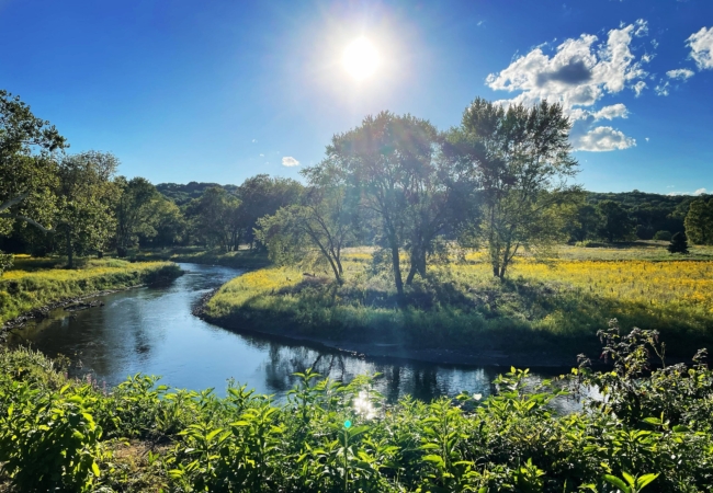 The sun shines in a bright blue sky over the winding Cuyahoga River.