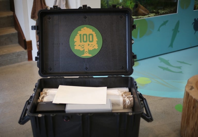 A black plastic case full of boxes and papers. The Summit Metro Parks centennial seal is on the inside of the lid.