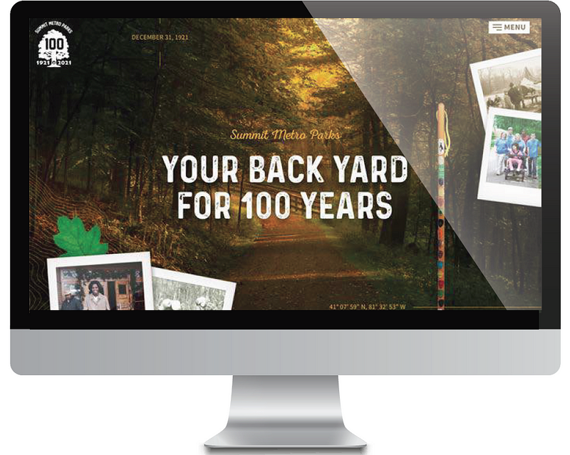A computer monitor displays the centennial website homepage