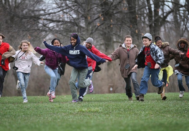 A group of kids running through a field.