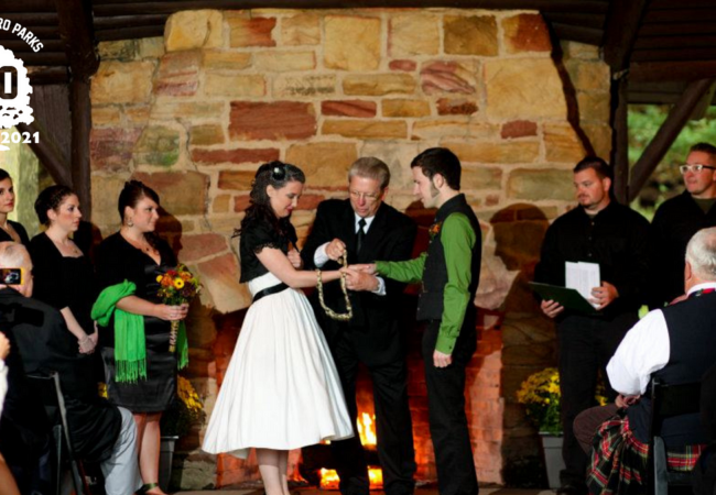 A couple celebrates with a wedding ceremony inside a lodge at Sand Run Metro Park.