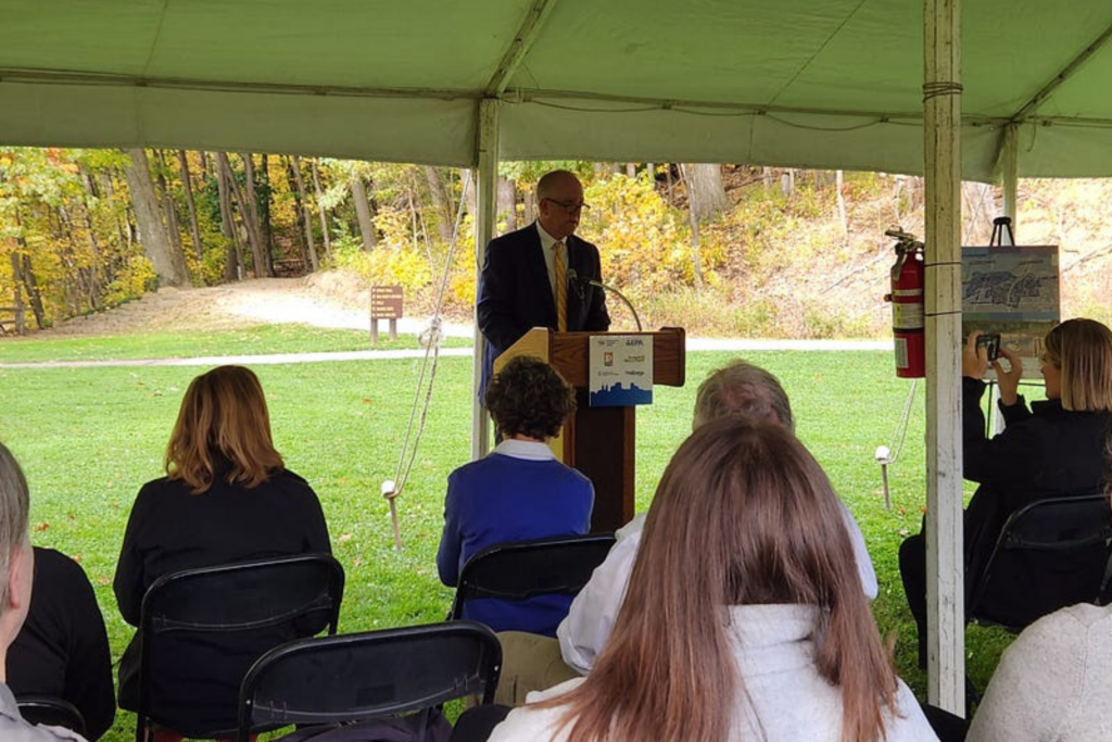 Akron Mayor Dan Horrigan speaks to a crowd of partners gathered at Gorge Metro Park to celebrate the new project agreement (2023), while sitting outside under a large event tent at Gorge Metro Park