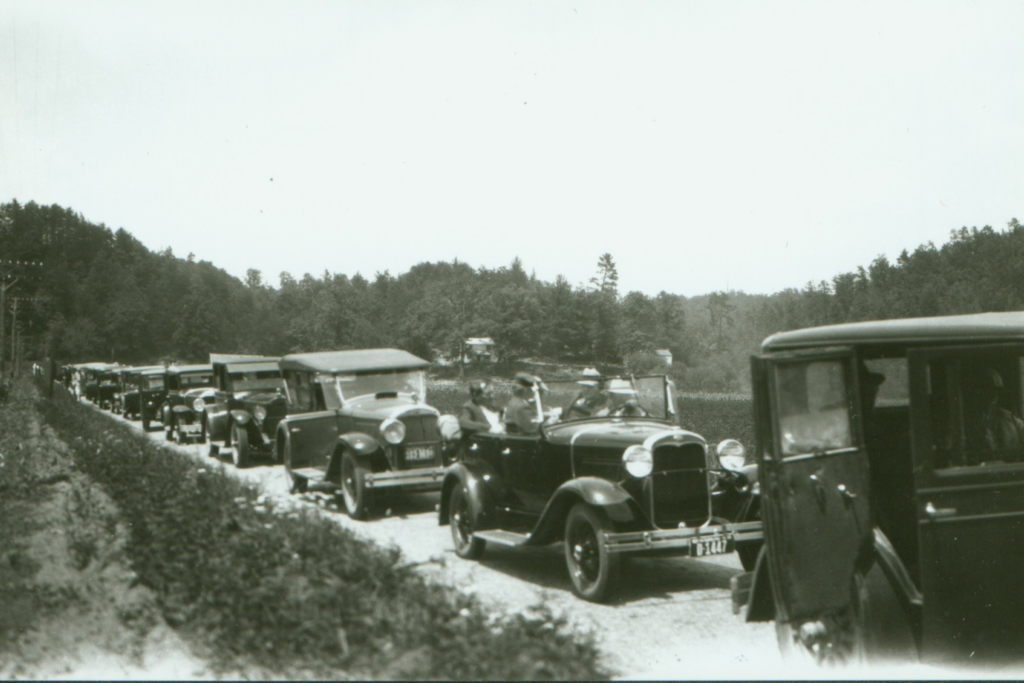 a line of cars fill the black and white image from left to right as they make their way down Sand Run Parkway in 1930