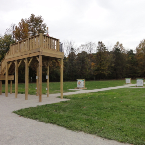 An archery platform in front of a field with several targets.