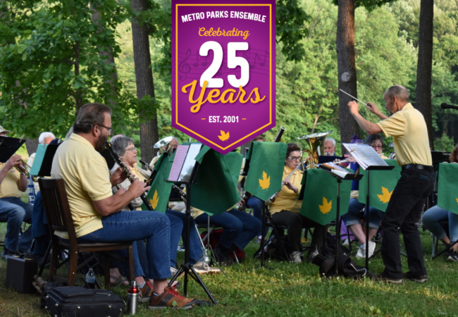 Musicians in yellow shirts sitting while playing instruments with lush greenery in the background. text overlay reads: Metro Parks Ensemble celebrates 25 years, est. 2001
