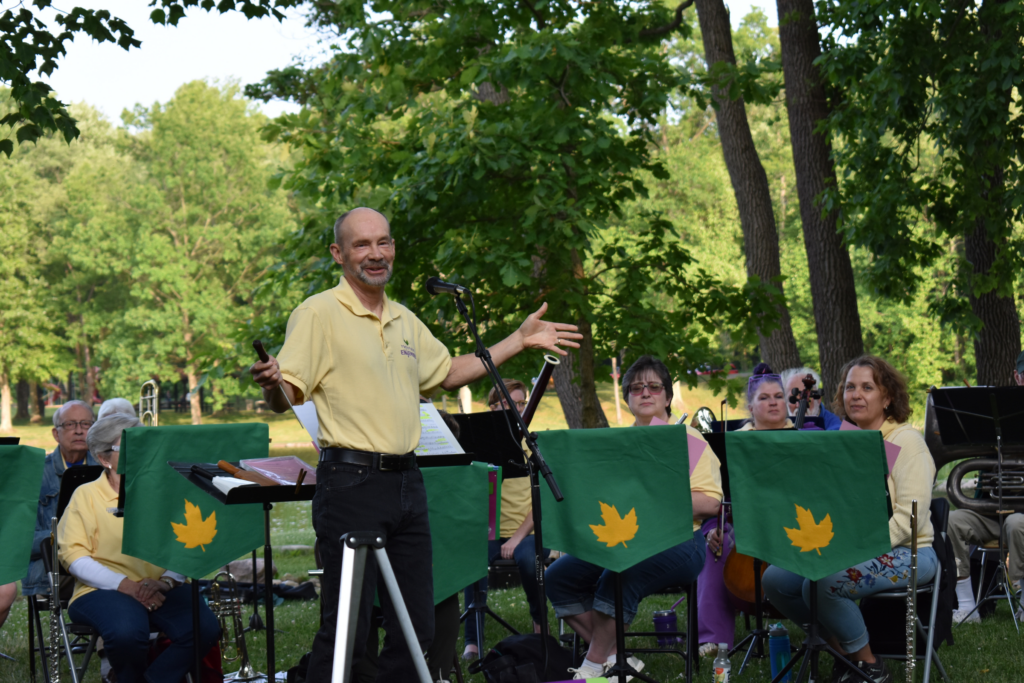 Volunteer Paul Wilkerson conducts the Metro Parks Ensemble during a 2023 Music by the Lake concert at Munroe Falls Metro Park.