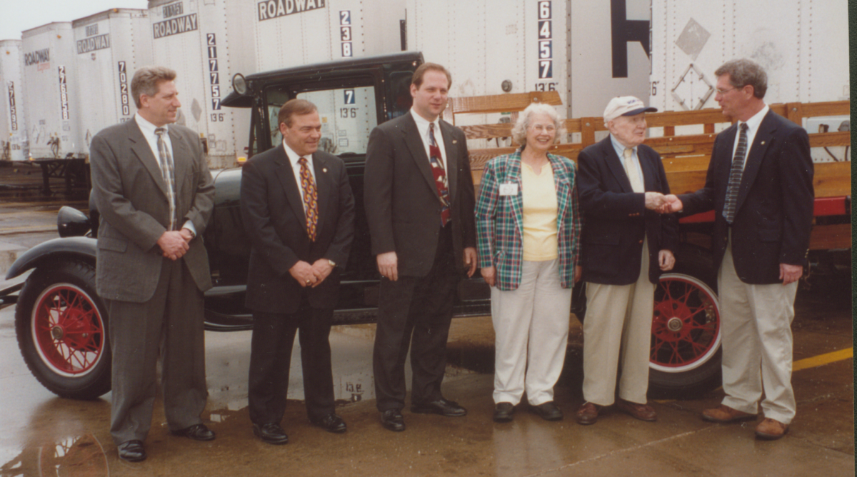 director-secretary Keith Shy stands with people from Summit Metro Parks Foundation in front of the Model AA truck being gifted to the park district
