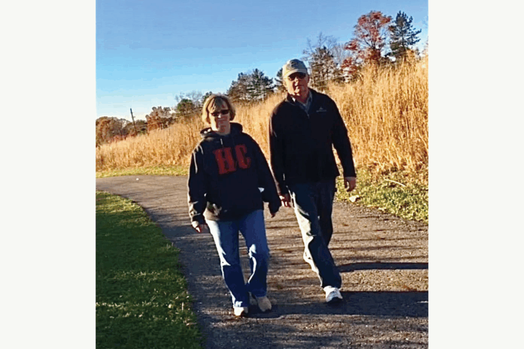 Susan and Rick, her late husband, wear hoodies and sunglasses while taking an autumn walk along the Bike & Hike Trail