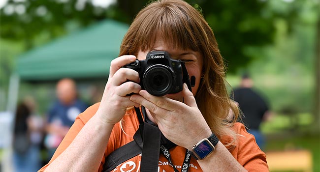 A photographer points a camera straight ahead, ready to shoot.