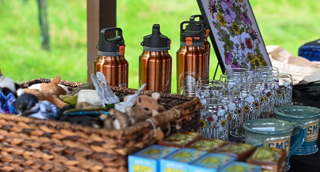 Various Summit Metro Parks branded items, including glasses, mugs and water bottes, arranged on a table.