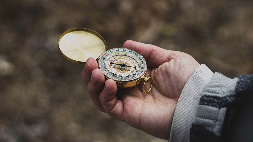 A compass held in a hand.