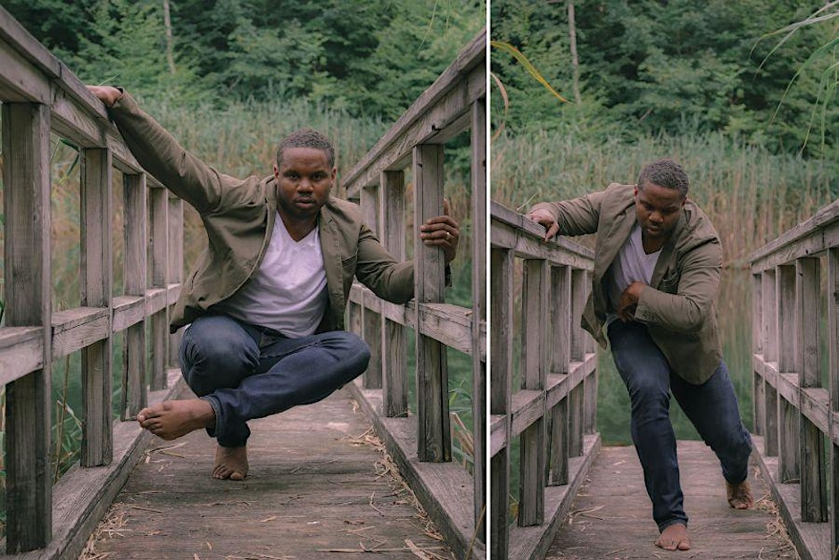 a person moves their body on a bridge with green trees in the background
