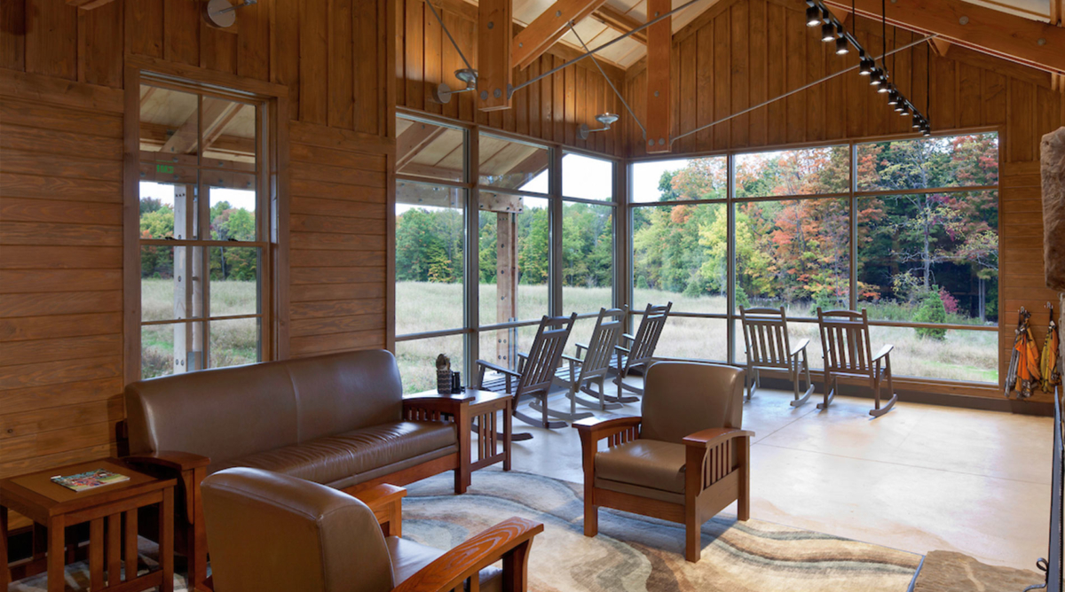 Chairs and a couch are spread out throughout a windowed room.